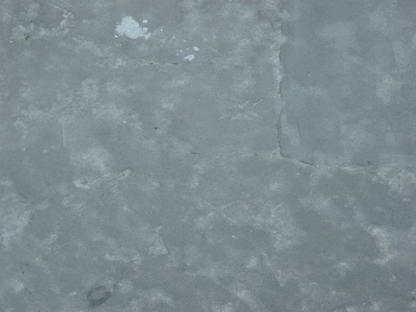 Asphalt texture, blue-grey in color, with blotchy light areas and small amounts of irregular cracking.